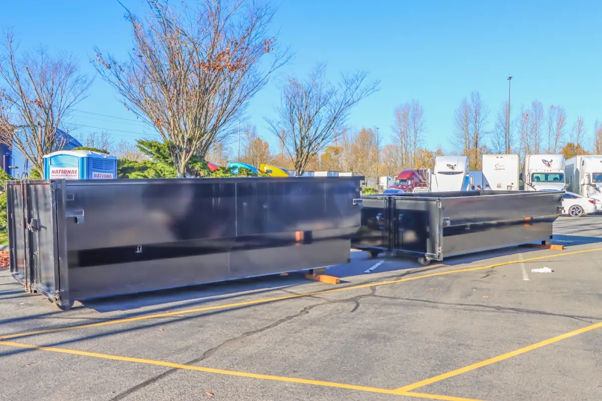 Professional dumpster rental service with roll-off container on residential driveway in Grants